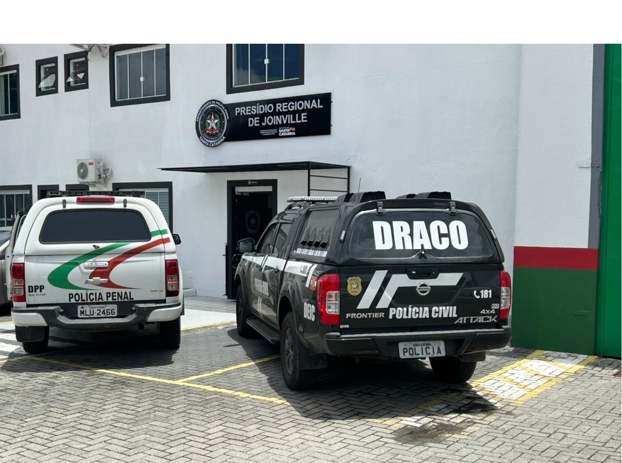 viatura policia civil no lado direito e viatura da policia penal no lado esquerdo, ambos em frente do prédio do presidio regional de Joinville