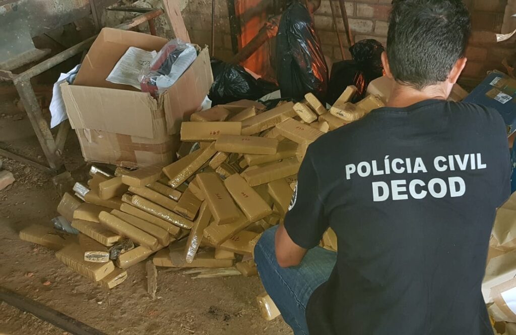 policial civil agachado envolta de 300 quilos de drogas em tablete