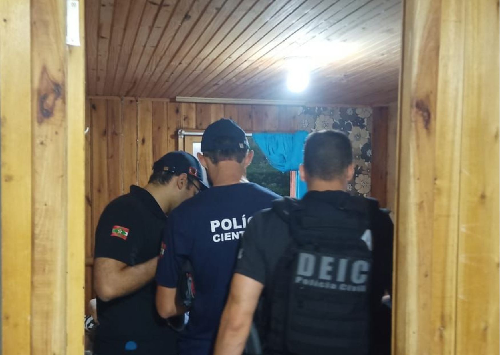 policiais da policia cientifica e civil dentro de um cômodo de uma casa
