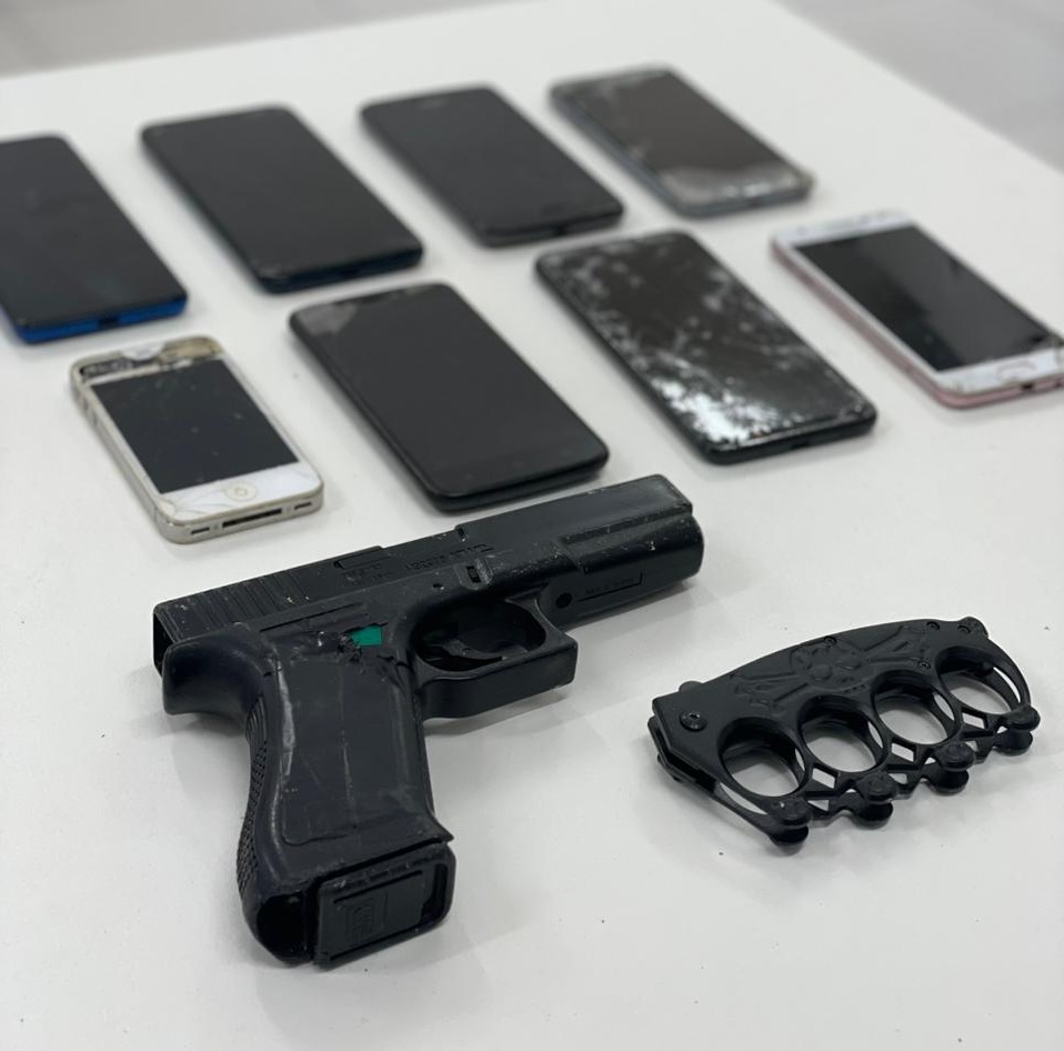 oito telefones celulares, um soco ingles e um simulacro de arma de fogo
