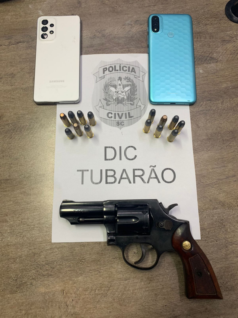 2 celulares, balas, arma e poster da DIC de Tubarão