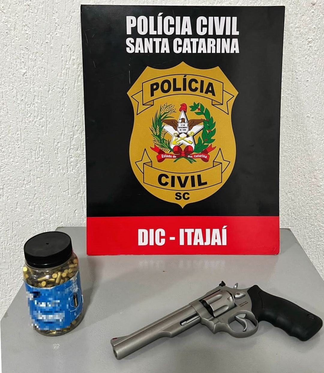 poster da dic de itajai, junto arma e um frasco com 400 munições
