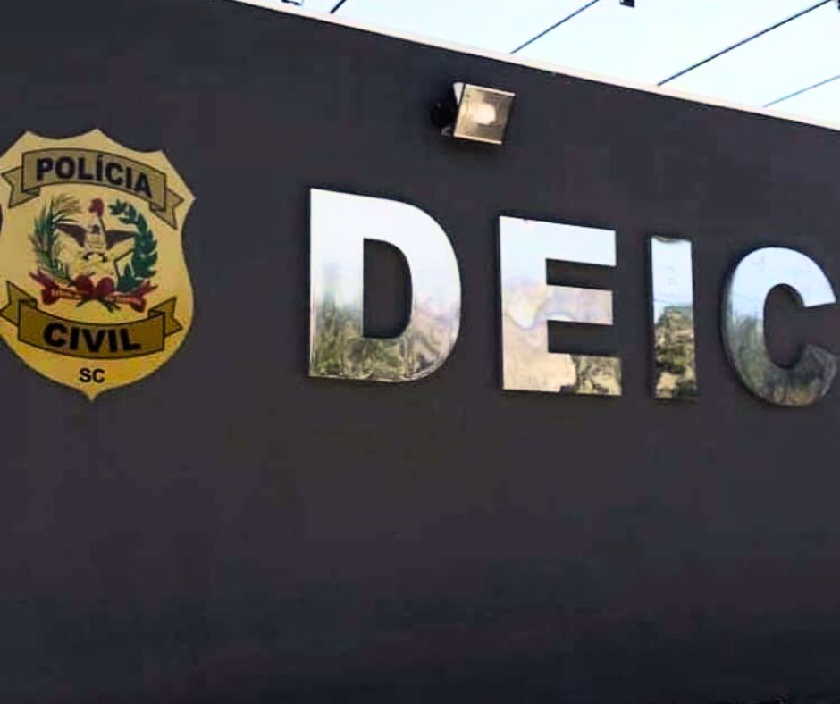 parede cinza com o símbolo da policia civil e a palavra DEIC em prata